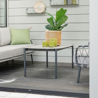 Dandelion Couchtisch in einem Wintergarten mit gelbem Blumentopf und Pflanzen