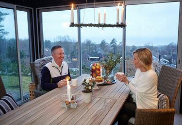 Wintergarten, ein Mann und eine Frau sitzen und trinken Kaffee in ihrem Wintergarten.